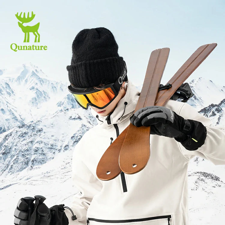 A man in ski gloves holding skis in the snow