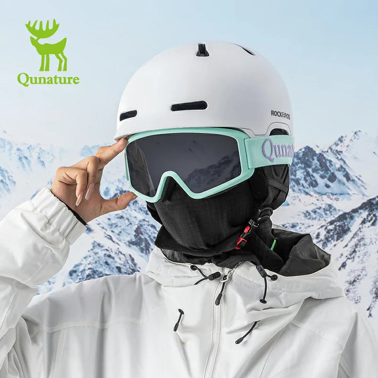 A man wearing a hooded snow helmet and ski goggles in the snow