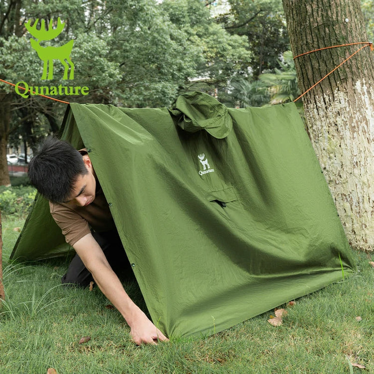 A man putting up a raincoat outdoors