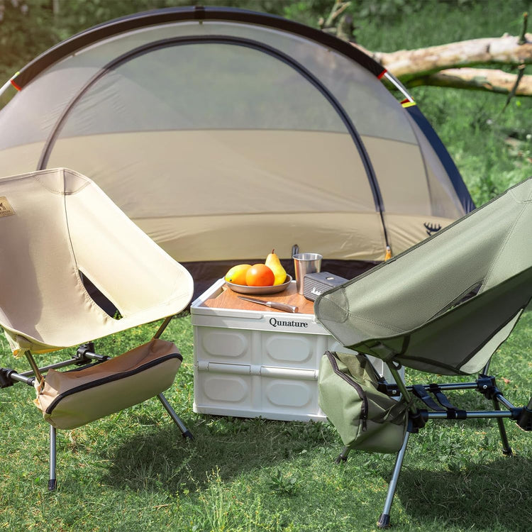 A tent, a folding table and two folding chairs outdoors