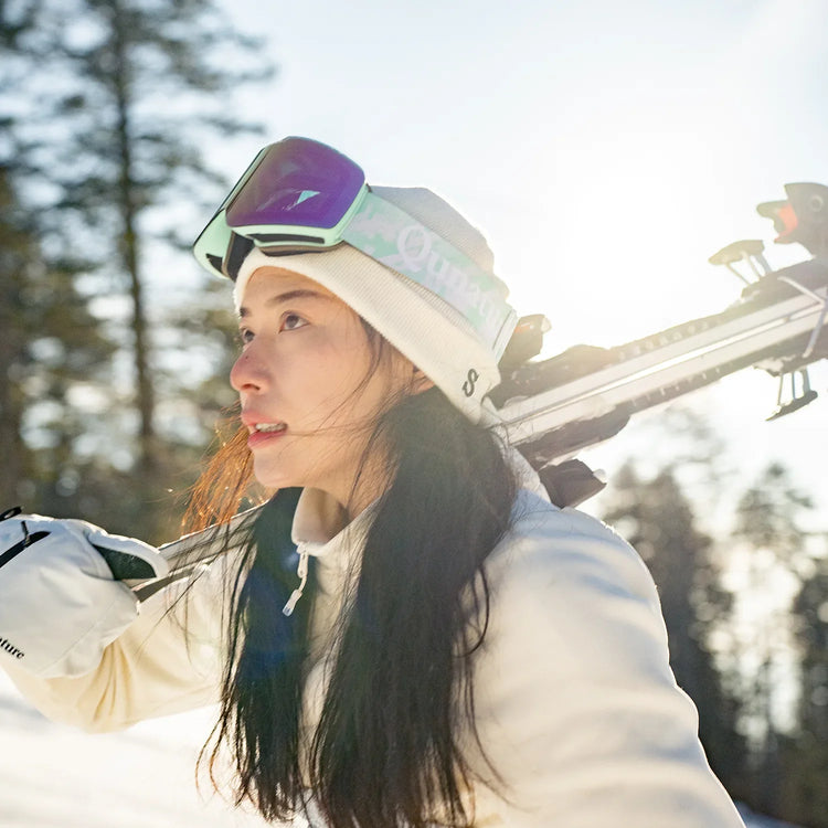 A pair of black-framed ski goggles with black straps and red lenses
