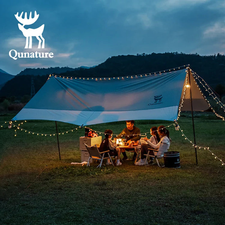 A man and four children sat and talked under a canopy at night