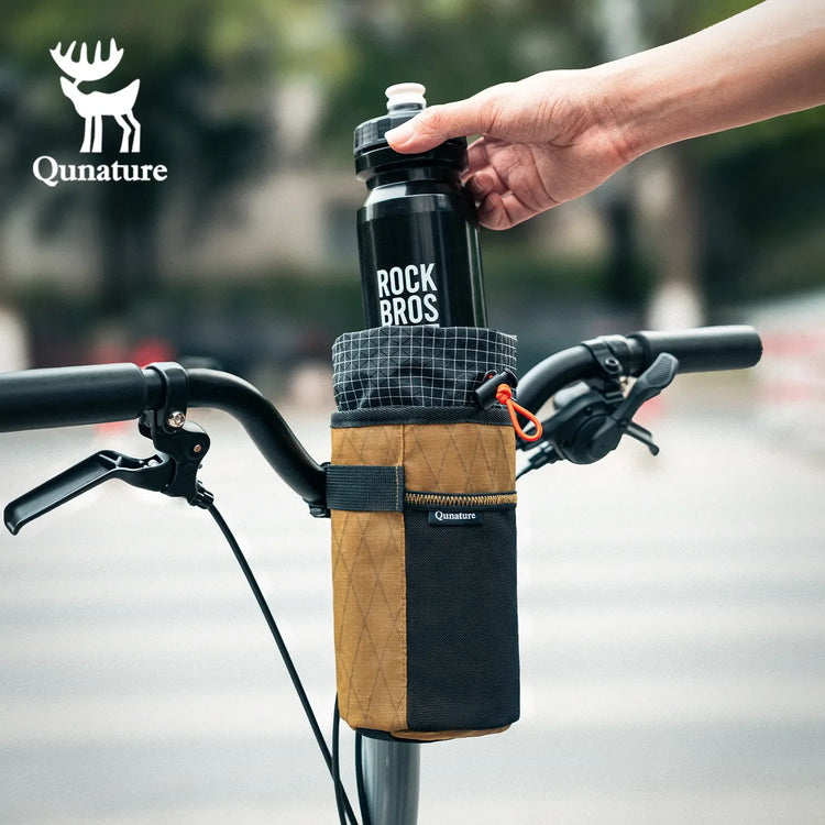 A person is putting a black water bottle into a khaki water bottle bag fixed on a bicycle