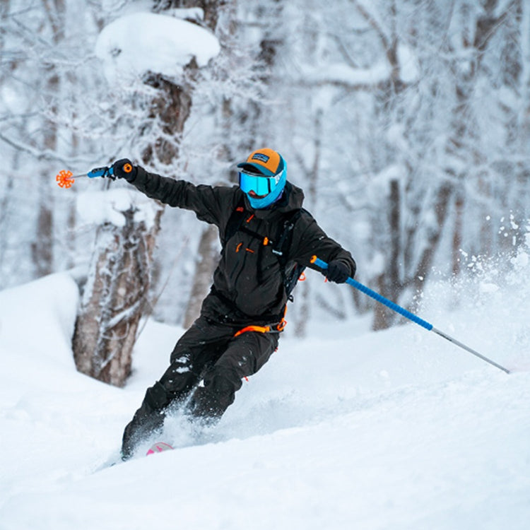 A person wearing a snow helmet skiing in the snow outdoors