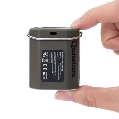 Small electronic device labeled 'Qunature' held by a hand on a white background