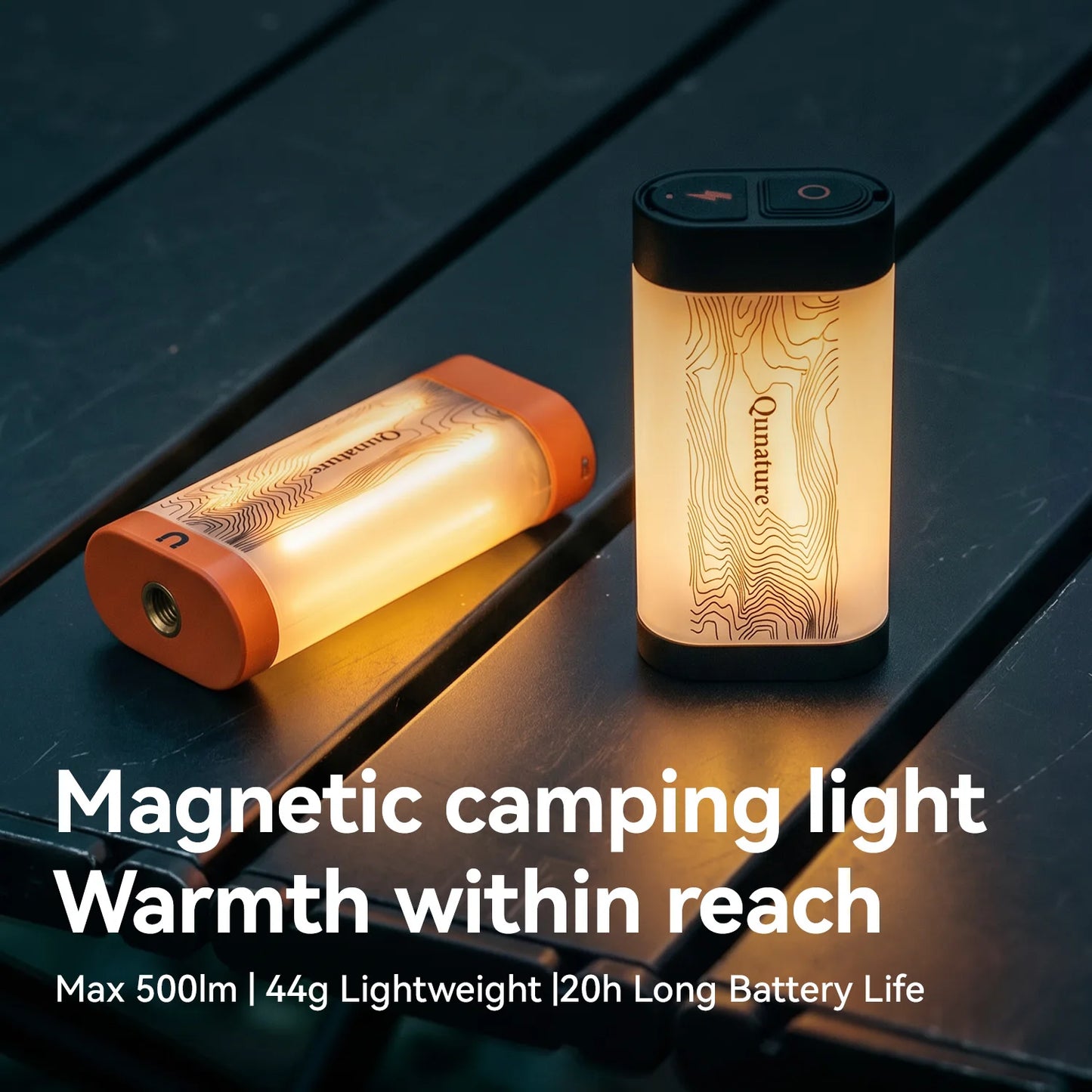 Two Qunature magnetic camping lights on a dark wooden surface, one standing upright and one lying on its side, both glowing with a warm light. White text at the bottom reads 'Magnetic camping light Warmth within reach Max 500lm | 44g Lightweight | 20h Long Battery Life'.