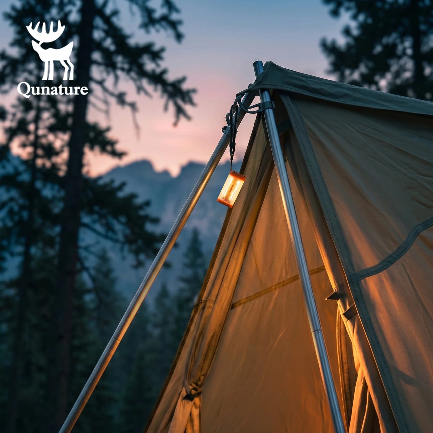 A Qunature brand tent pitched outdoors in a forest at dusk, with a warm lantern hanging from the peak and mountains visible in the background.