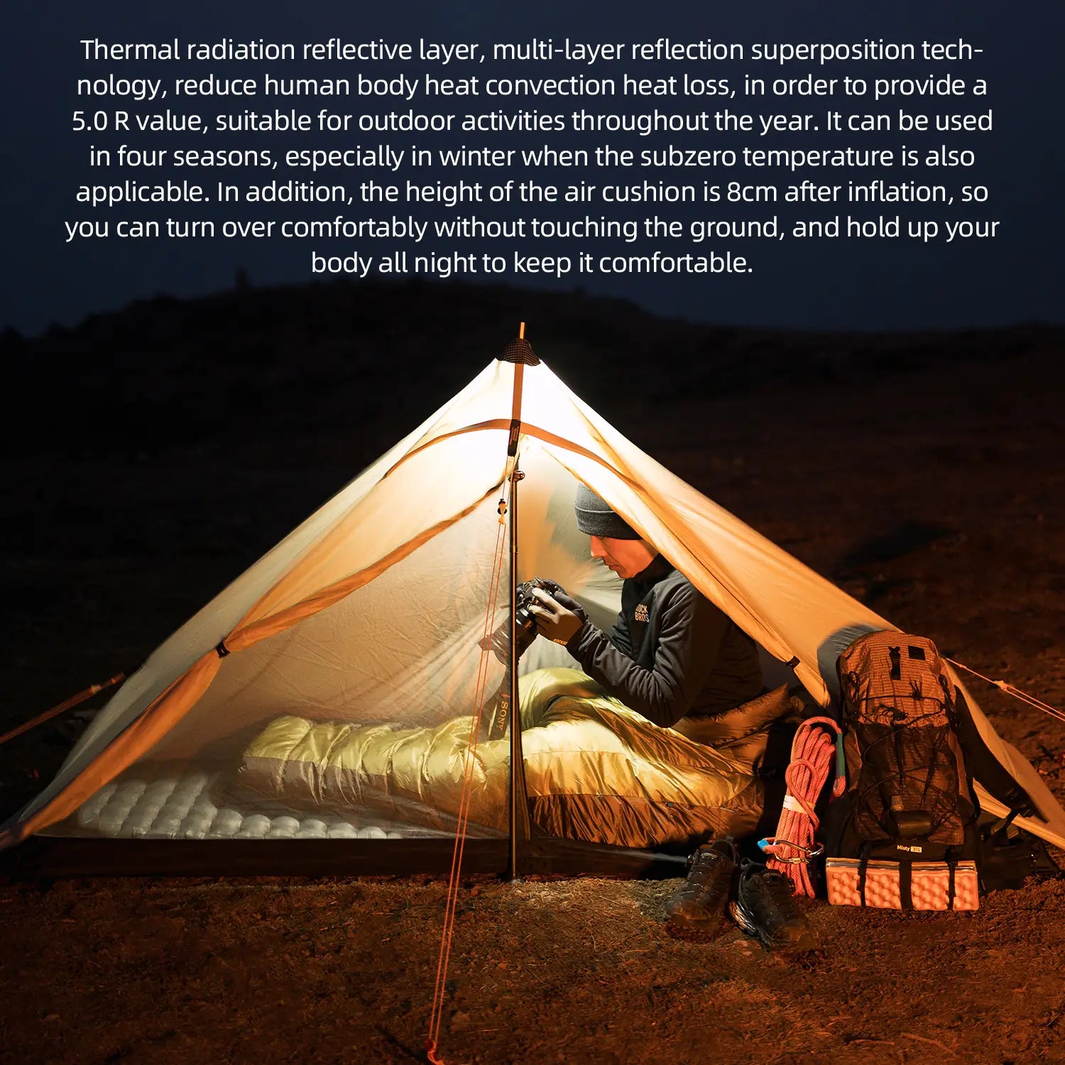 Person camping under a illuminated tent with text about thermal radiation reflective layer technology.