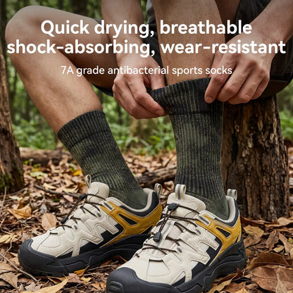 A person sitting outdoors in a wooded setting is shown putting on a dark ribbed athletic sock, with hiking shoes visible. Large text at the top reads: 'Quick drying, breathable shock-absorbing, wear-resistant 7A grade antibacterial sports socks.