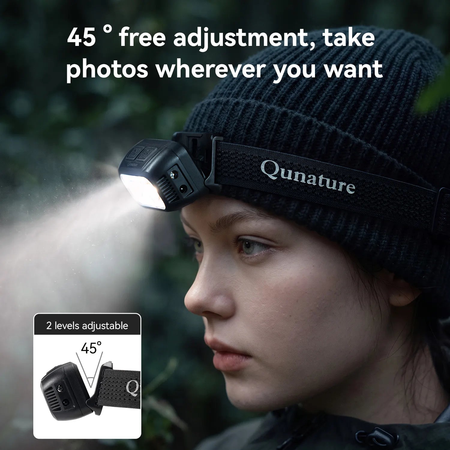 A person wearing a black beanie and dark jacket outdoors, with a Qunature headlamp mounted on the beanie. The lamp is turned on and emitting a beam of light to the left.
