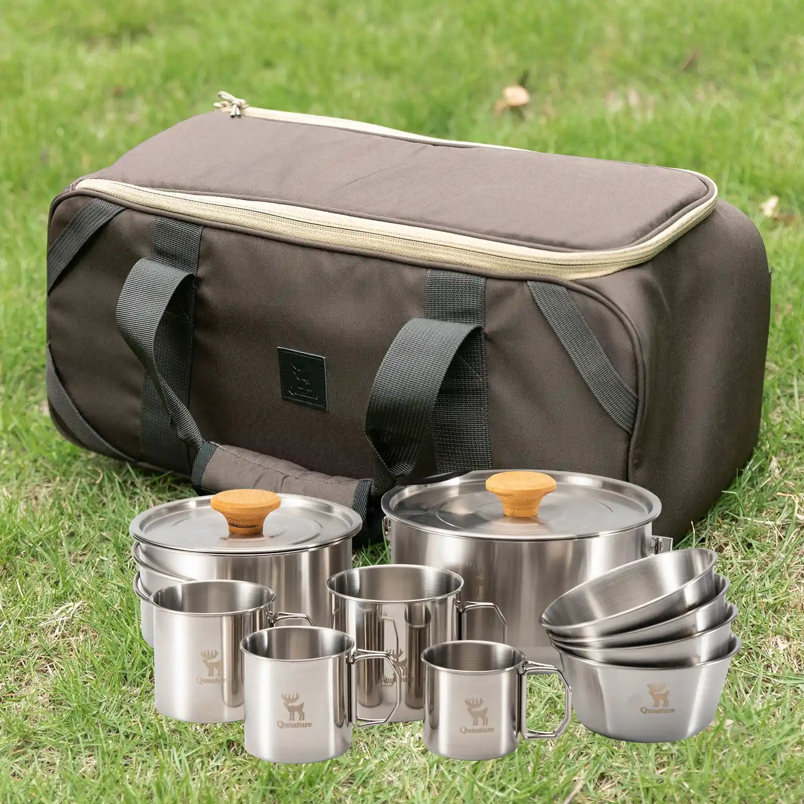 Set of stainless steel camping cookware with a carrying bag on grass