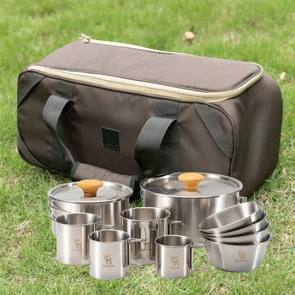 Set of stainless steel camping cookware with a carrying bag on grass