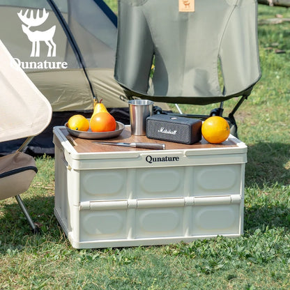 Camping scene with a Qunature cooler box, fruit, and a Marshall speaker in front of a tent.