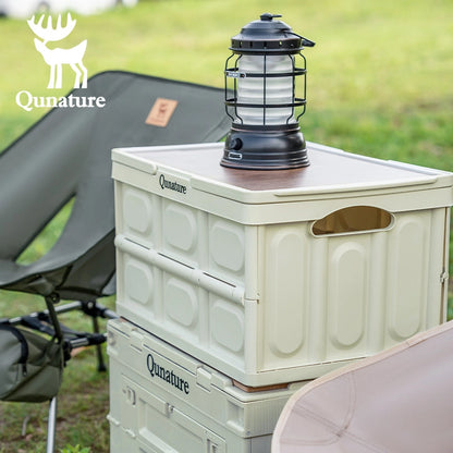 Stack of Qunature coolers with a lantern on top, outdoors.