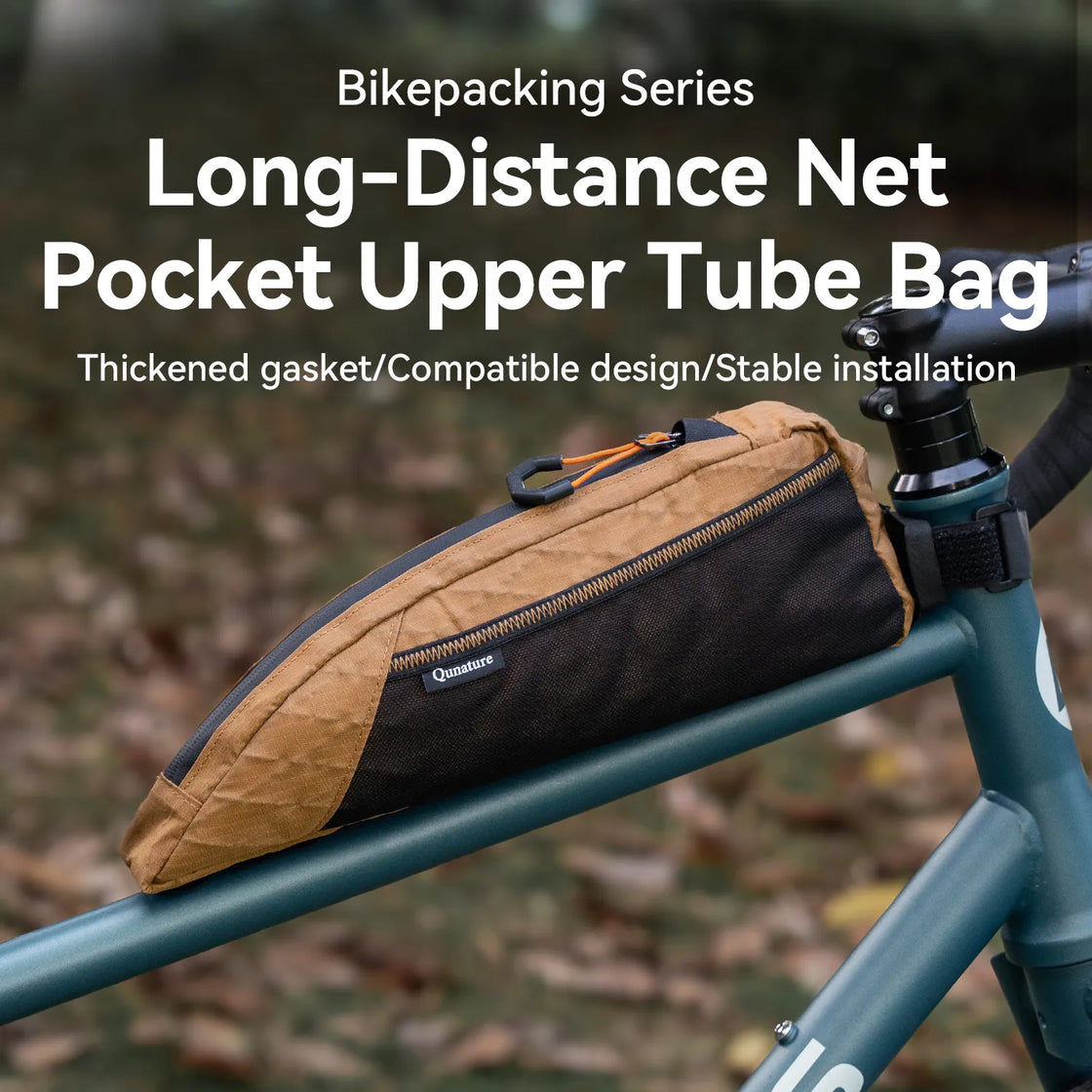 A khaki top tube bike bag with lots of storage pockets is mounted on a bicycle outdoors