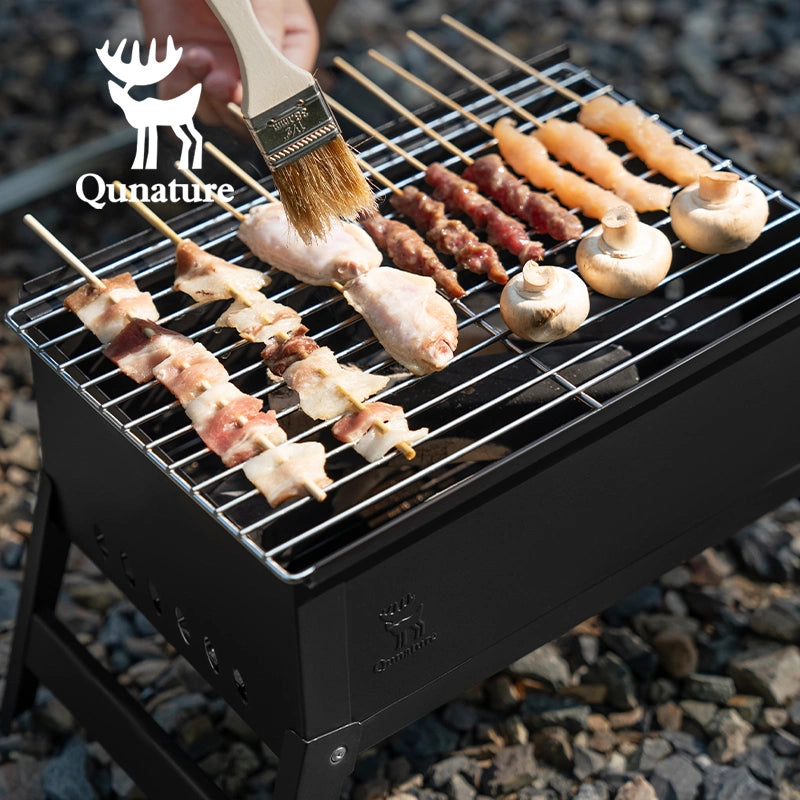Grill with skewers of meat and vegetables being brushed with a marinade, branded 'Qunature'.