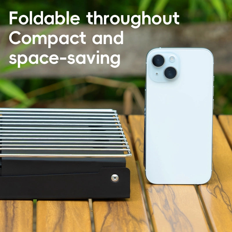 Foldable grill and smartphone on a wooden surface with text 'Foldable throughout Compact and space-saving'.
