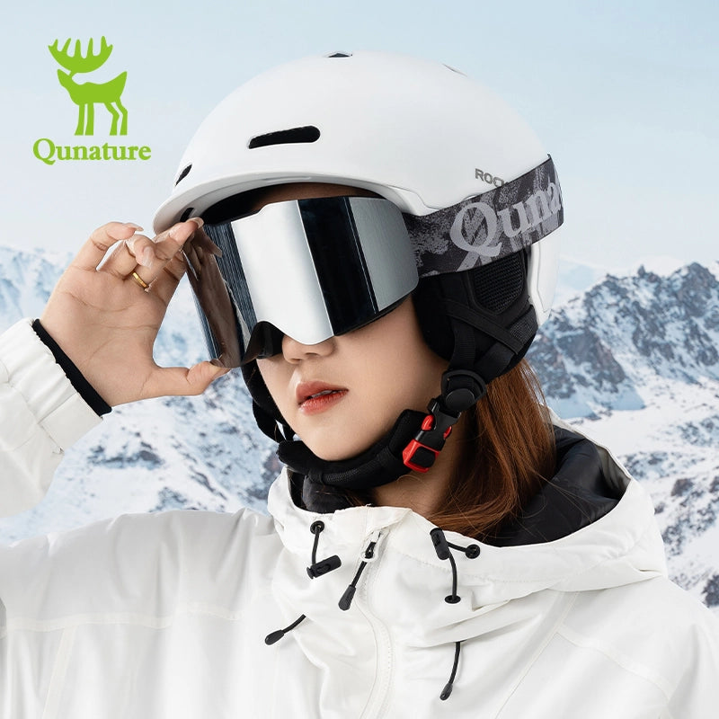 A girl wearing frameless silver anti-fog ski goggles and a snow helmet