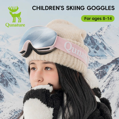 A girl wearing a pair of kids anti-fog ski goggles with UV protection, with pink straps and grey lenses