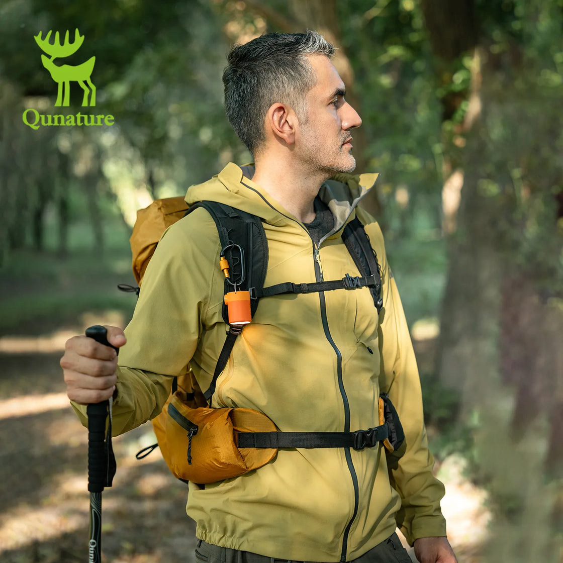 A man carrying a lightweight waterproof hiking backpack and holding trekking poles