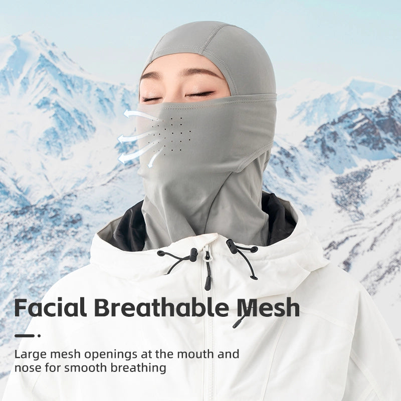 Person wearing a gray face mask with mesh openings against a mountainous background