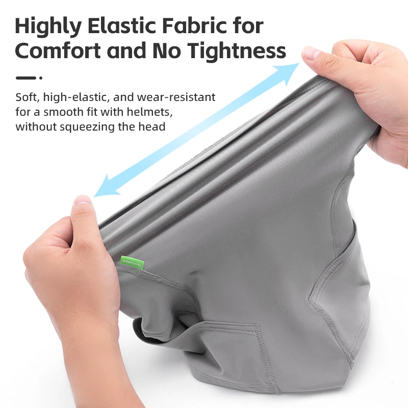 Gray helmet liner with hands demonstrating its elasticity on a white background