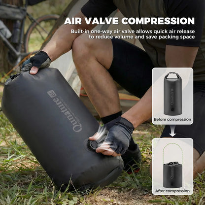 Person using a black compression bag with an air valve feature, set outdoors.