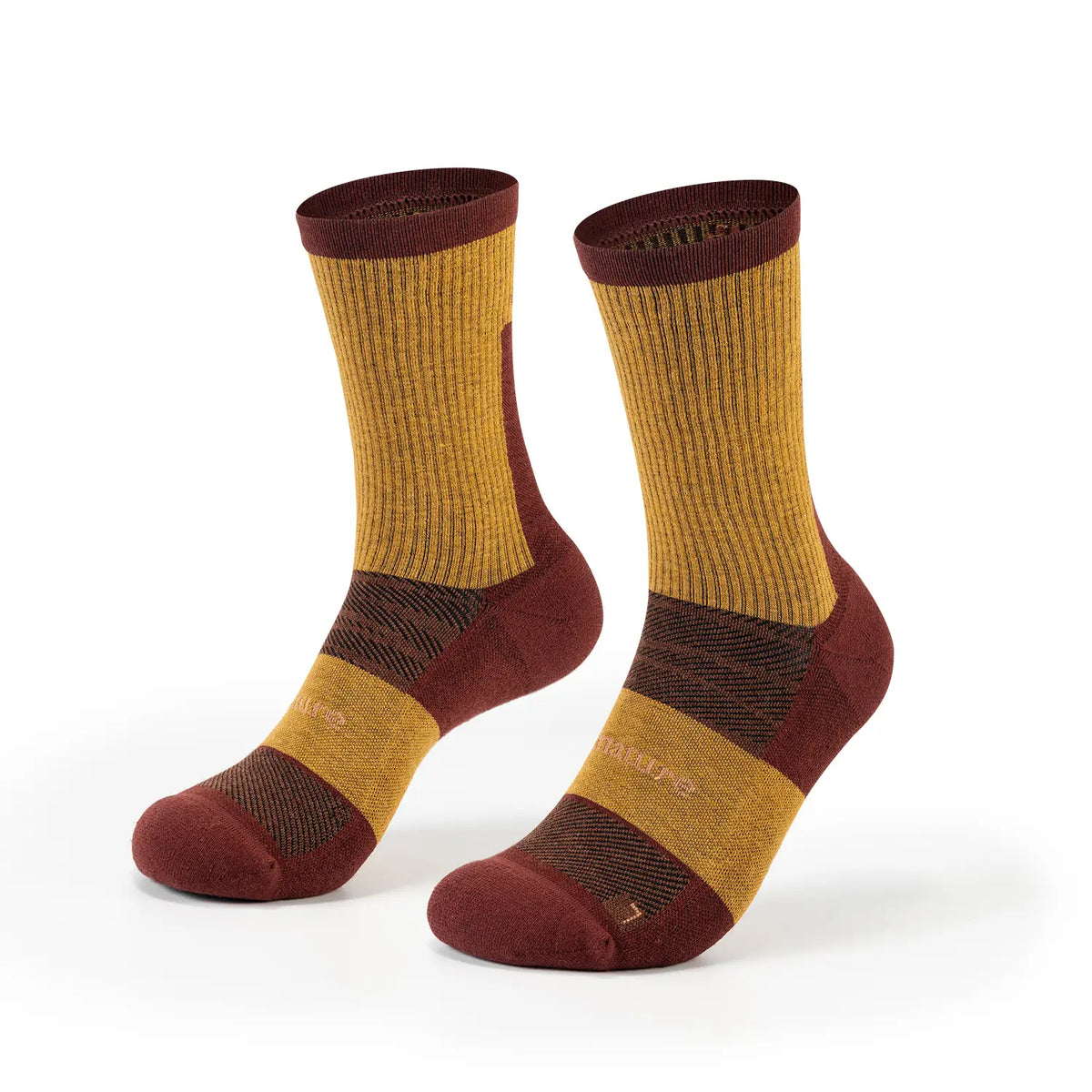 A pair of crew socks in a color-blocked pattern of mustard yellow, dark brown, and burgundy, displayed on a clean white background.