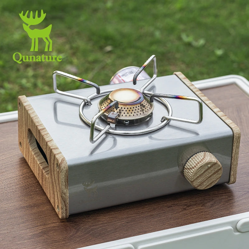Portable gas stove with wooden base on a table, Qunature brand visible