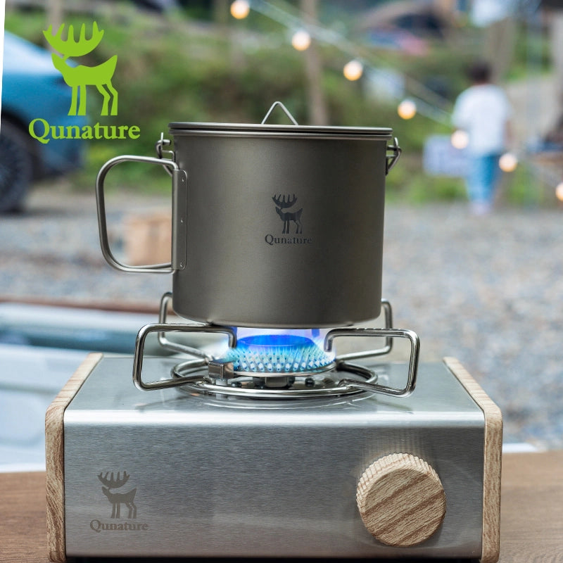 Portable stove with pot on a blurred outdoor background, featuring Qunature branding.