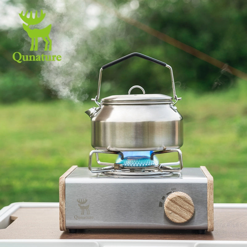 Portable stove with a kettle on a natural background, featuring the Qunature brand.