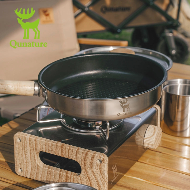 Cooking pan on a portable stove with Qu nature brand logo in the background