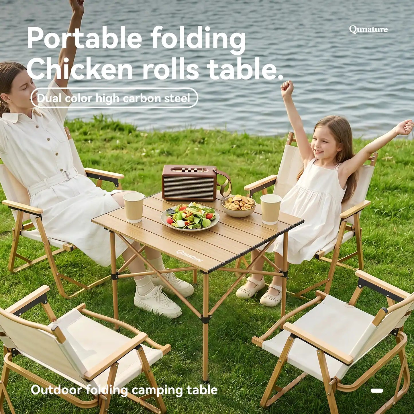 Two people sitting at a portable folding table outdoors by a body of water.