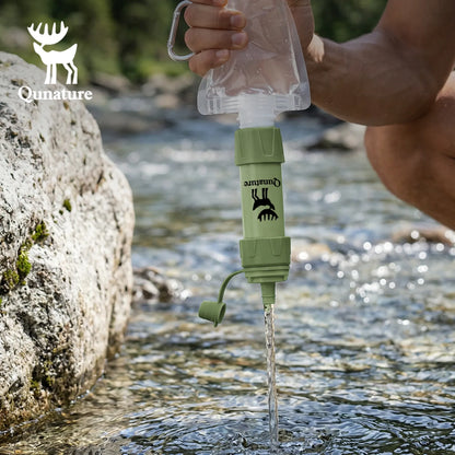 Person using a portable water filter device in a natural setting with Quinature branding.