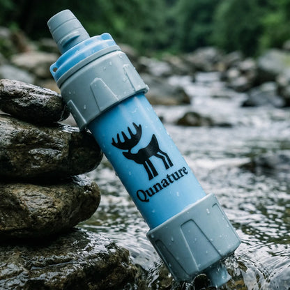 Qunature water filter bottle with a deer logo on a rock by a stream