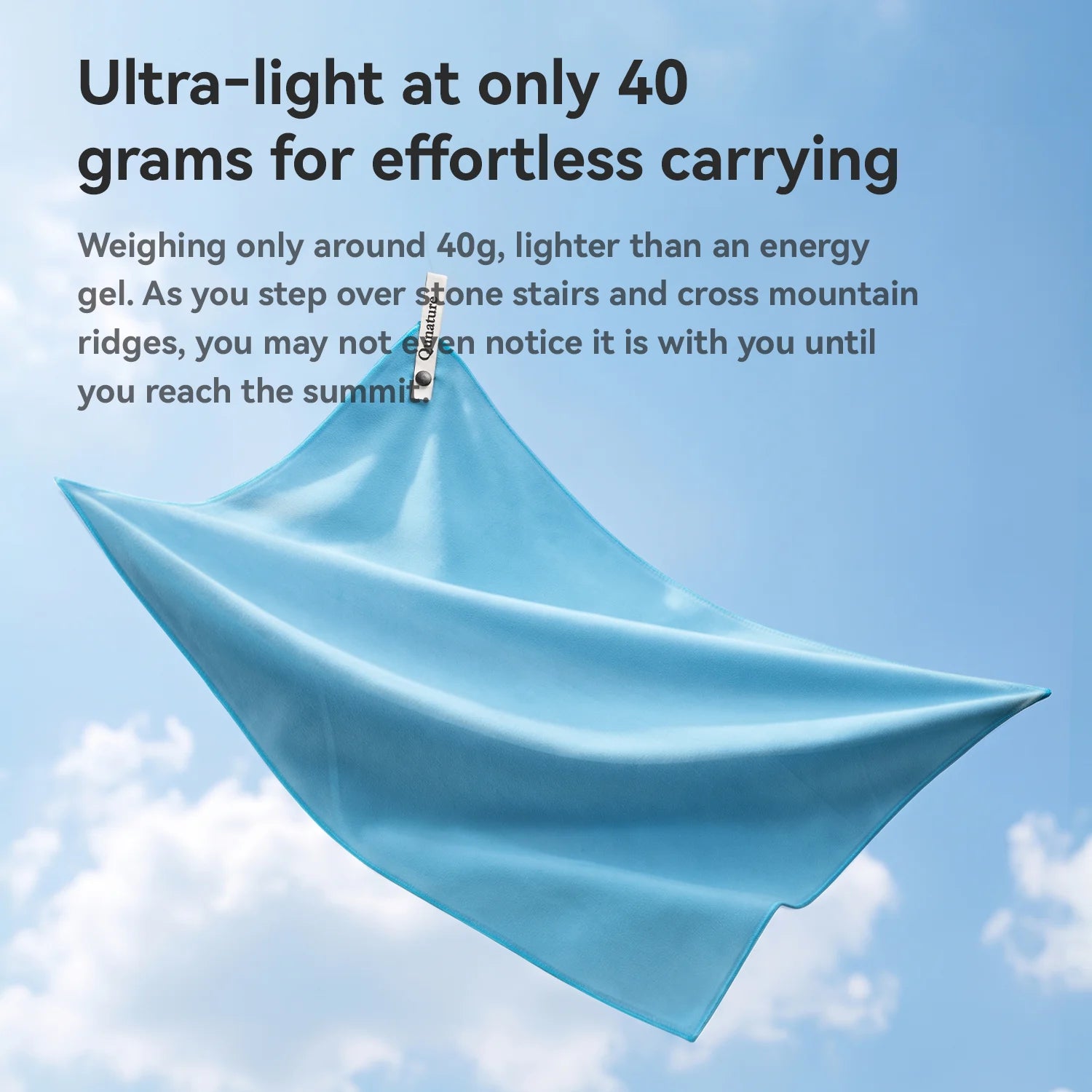 A light blue lightweight fabric sheet or towel shown flying against a blue sky background with clouds, accompanied by promotional text about its low weight and ease of carrying.