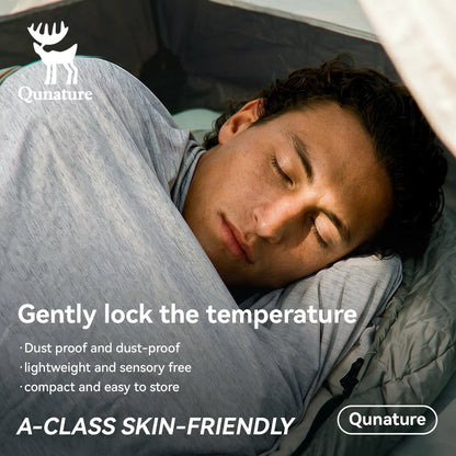 Person sleeping in a Qunature sleeping bag with product features highlighted.
