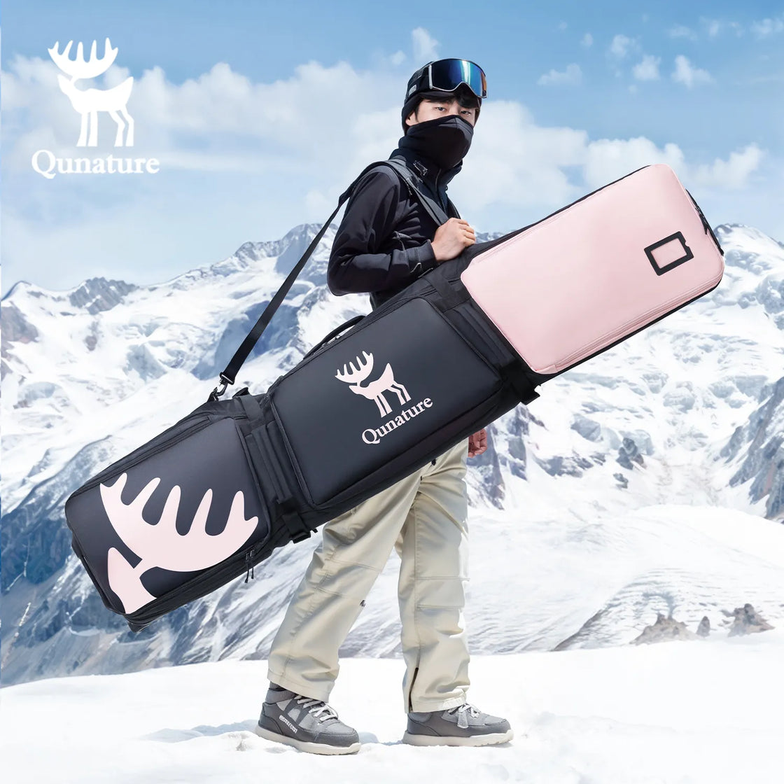 A boy wearing a mask and carrying a pink snowboard bag on the snow