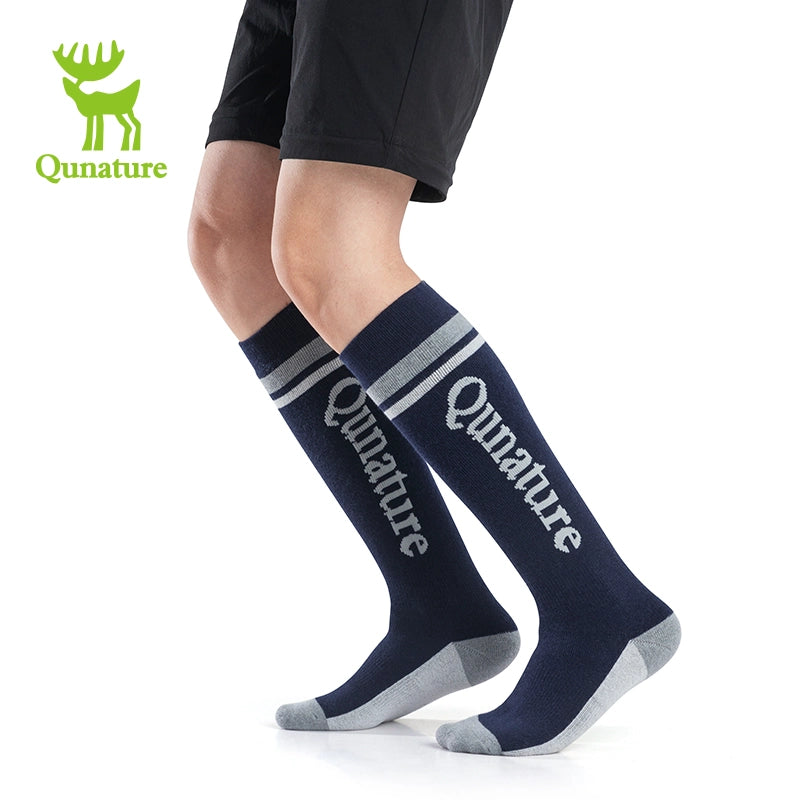 A person wearing dark blue long ski socks with lettering