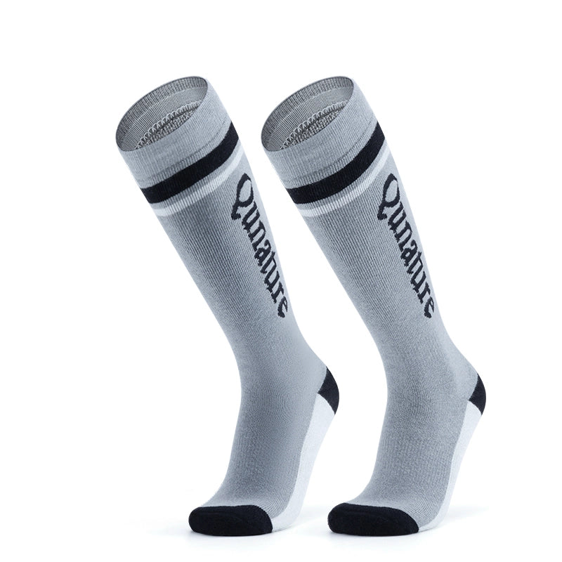 A pair of grey long ski socks with monogram pattern