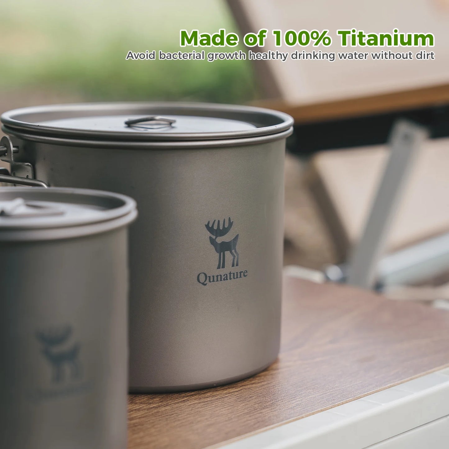 Titanium drinking cups with Qunature logo on a wooden surface