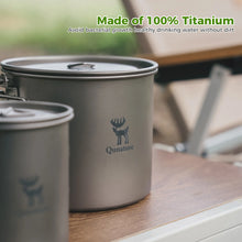 Titanium drinking cups with Qunature logo on a wooden surface