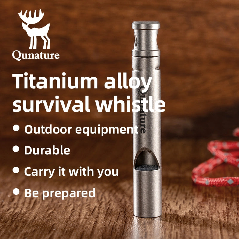 Titanium alloy survival whistle with Qunature branding on a wooden background