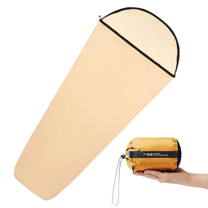 Beige sleeping pad with black trim and a hand holding a compact orange sleeping pad with a black logo.