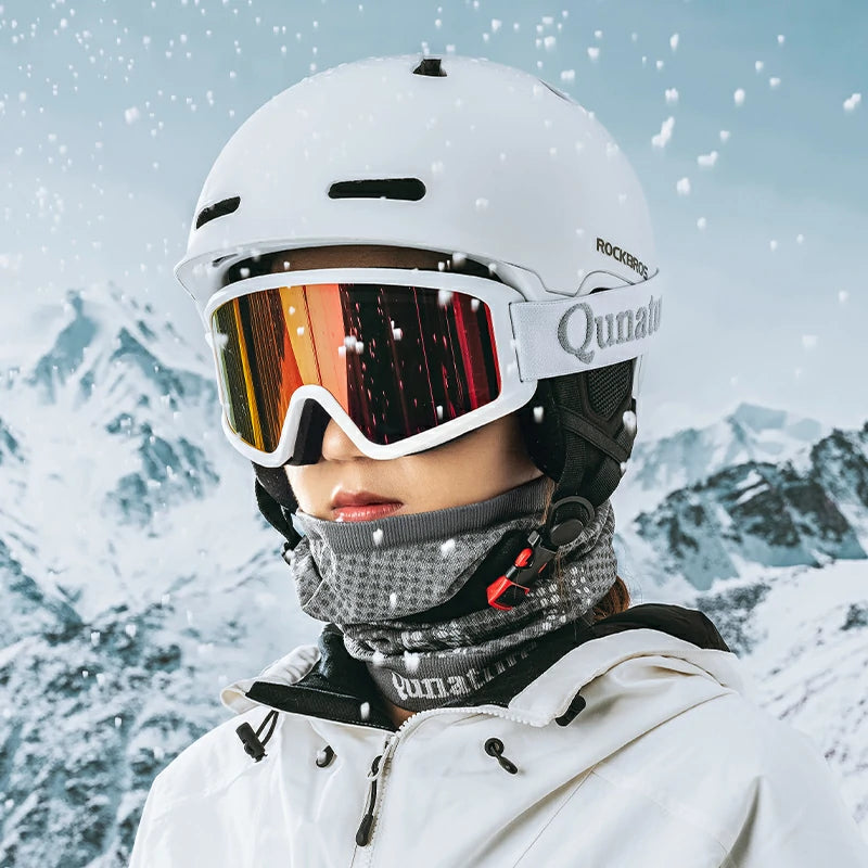 A woman wearing a snow helmet and a black mask in the snow