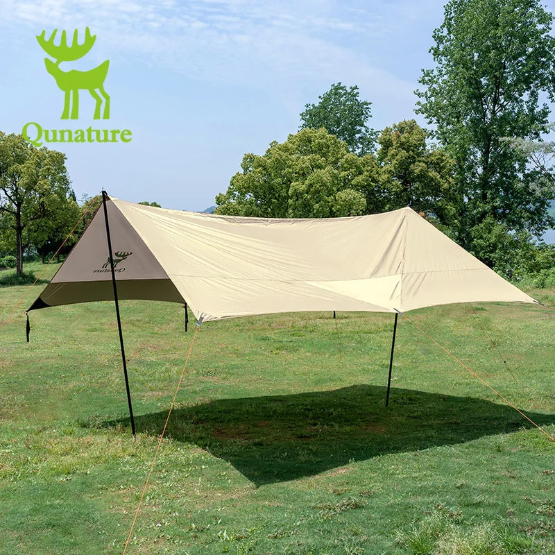 Beige camping tarp with black poles on grassy area with trees in the background, featuring Qunature logo.