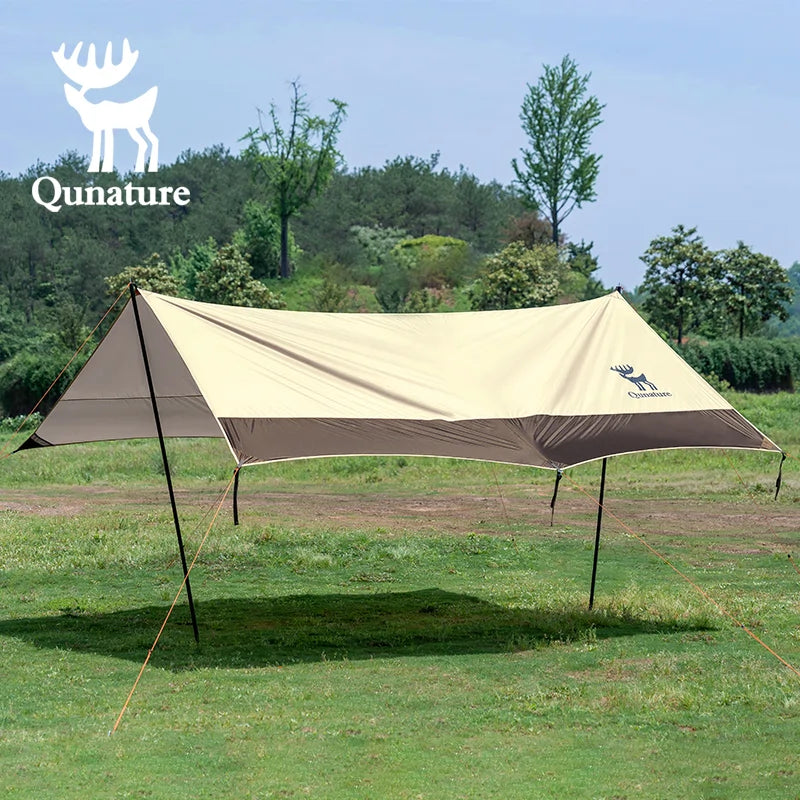 Camping tarp with Qunature logo on a grassy field with trees in the background