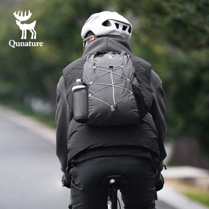 Person wearing a black jacket and helmet with a Black backpack, riding a bike on a road.