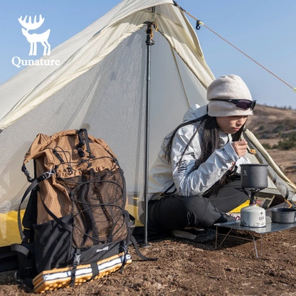 A khaki hiking backpack was placed on the ground, and a girl was sitting in a tent next to it eating.