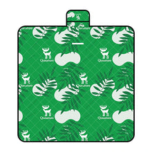 A Qunature branded outdoor picnic mat with a patterned design featuring elements like mountains, trees, and camping gear, in green, beige, and other colors.